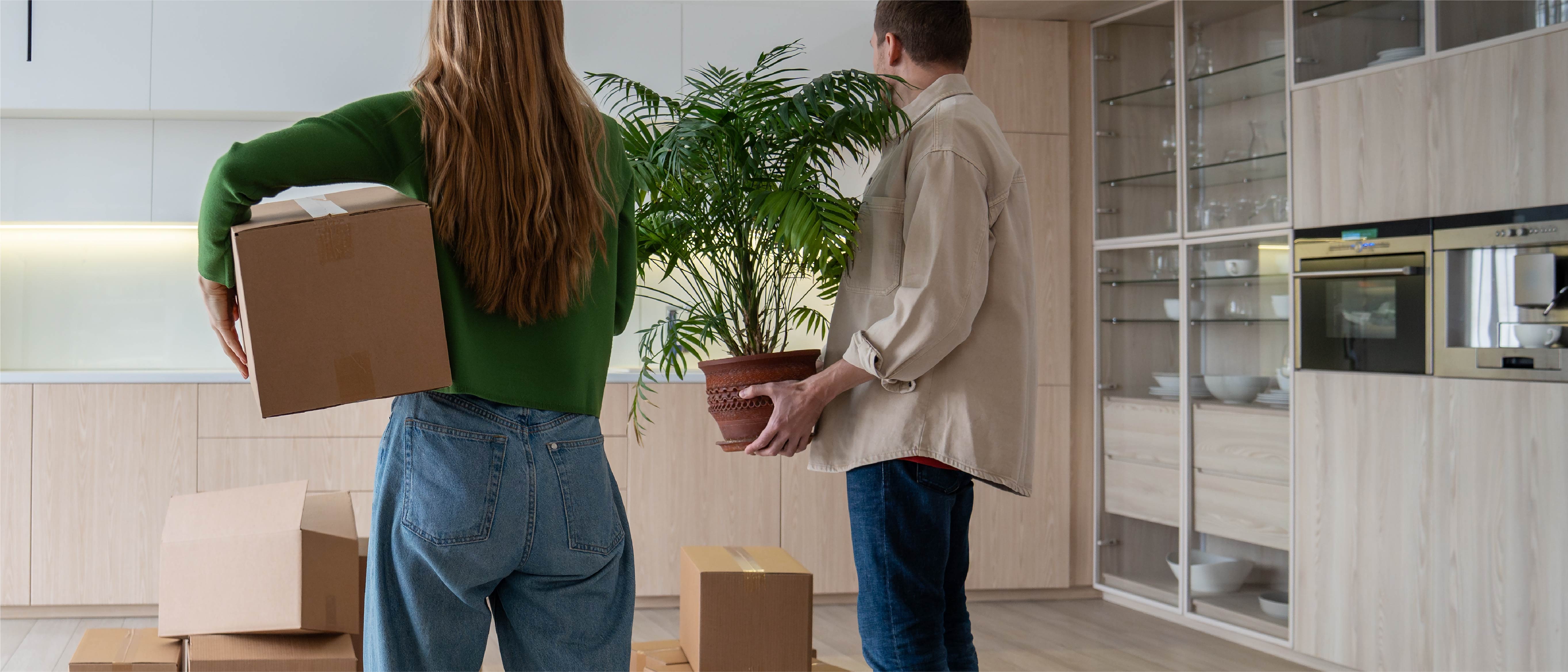 Couple moving boxes into a new home
